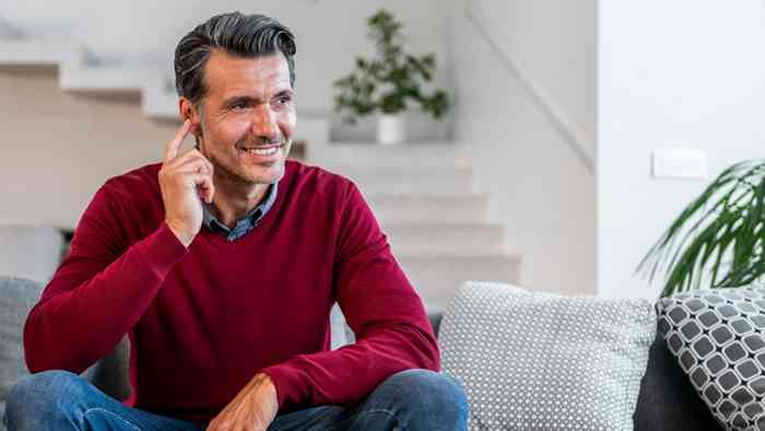 Senhor ajusta o aparelho auditivo no ouvido direito