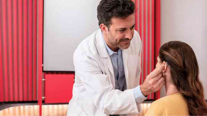 audiologista coloca aparelho ITE no ouvido da cliente