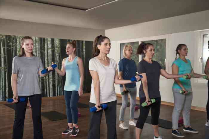 Senhoras em aula de ginástica, onde algumas utilizam aparelhos auditivos ou implantes cocleares para melhor audição.