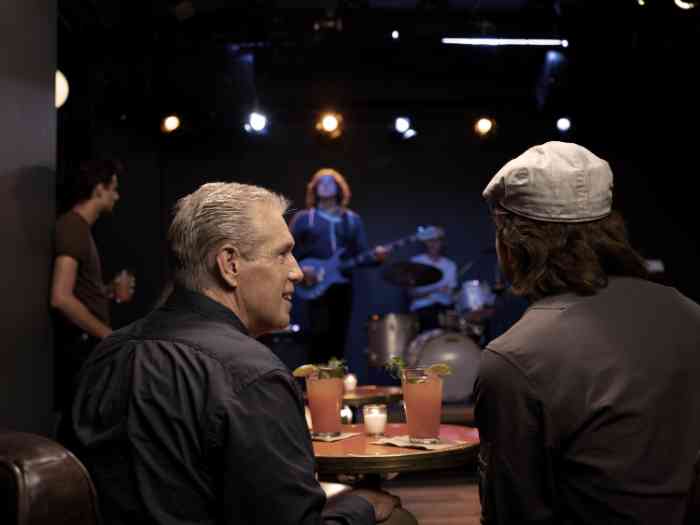 Amigos conversa, e desfrutam do som do concerto.