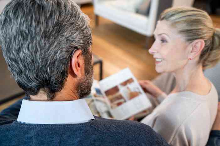 Casal, homem e mulher, a conversarem na sala de estar