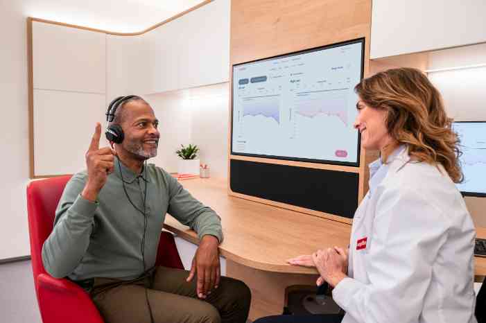 Audiologista num centro auditivo Minisom, a realizar um exame auditivo num paciente