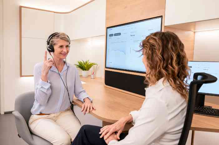 Senhora a realizar um exame auditivo com uma audiologista num centro auditivo Minisom