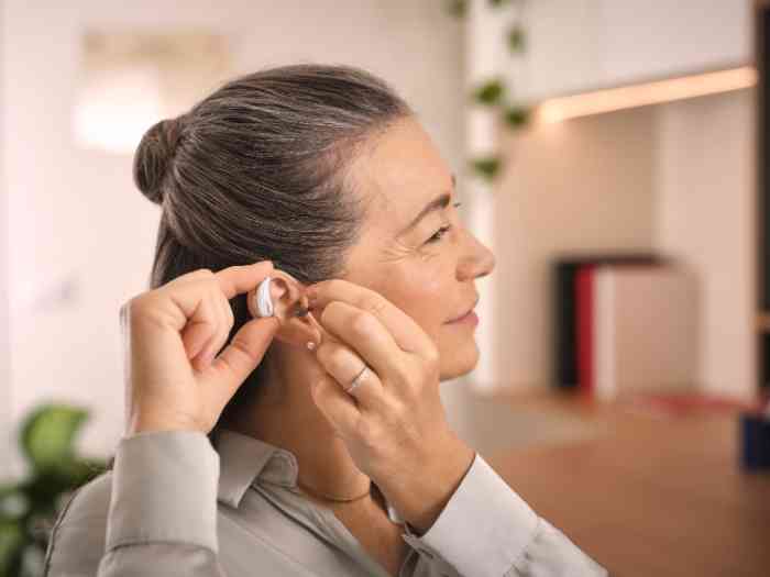 senhora a colocar aparelho auditivo