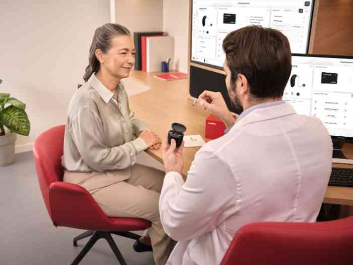 audiologista a mostrar aparelhos auditivos a cliente