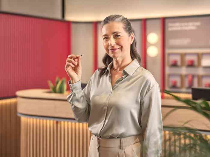 cliente com aparelho auditivo ampli-mini na mão