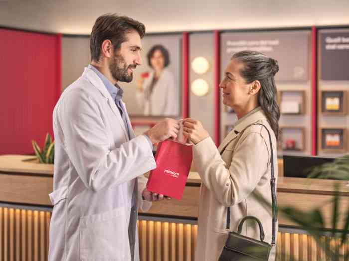 audiologista entrega a cliente saco aparelhos auditivos.