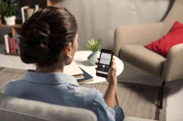 Senhora prepara-se para fazer teste auditivo online no seu telemóvel.