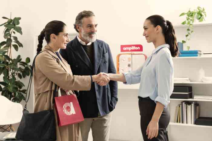 dois clientes, homem e mulher, a cumprimentar a audiologista