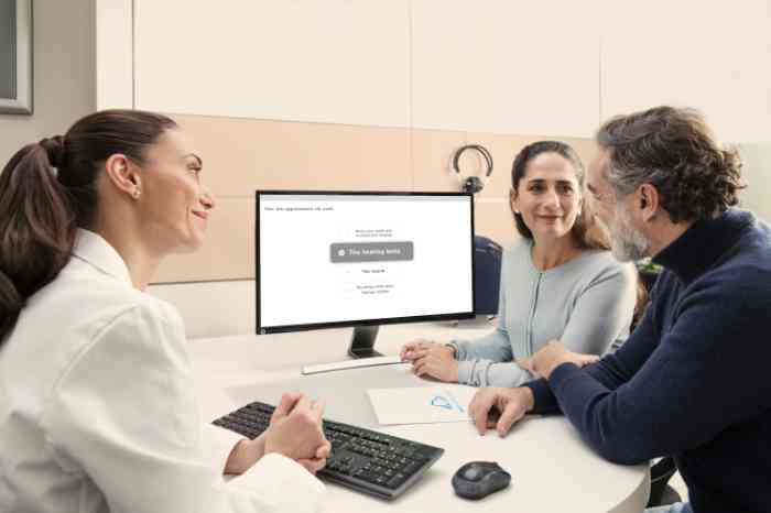 Audiologista mostra resultados de audiometria a casal.
