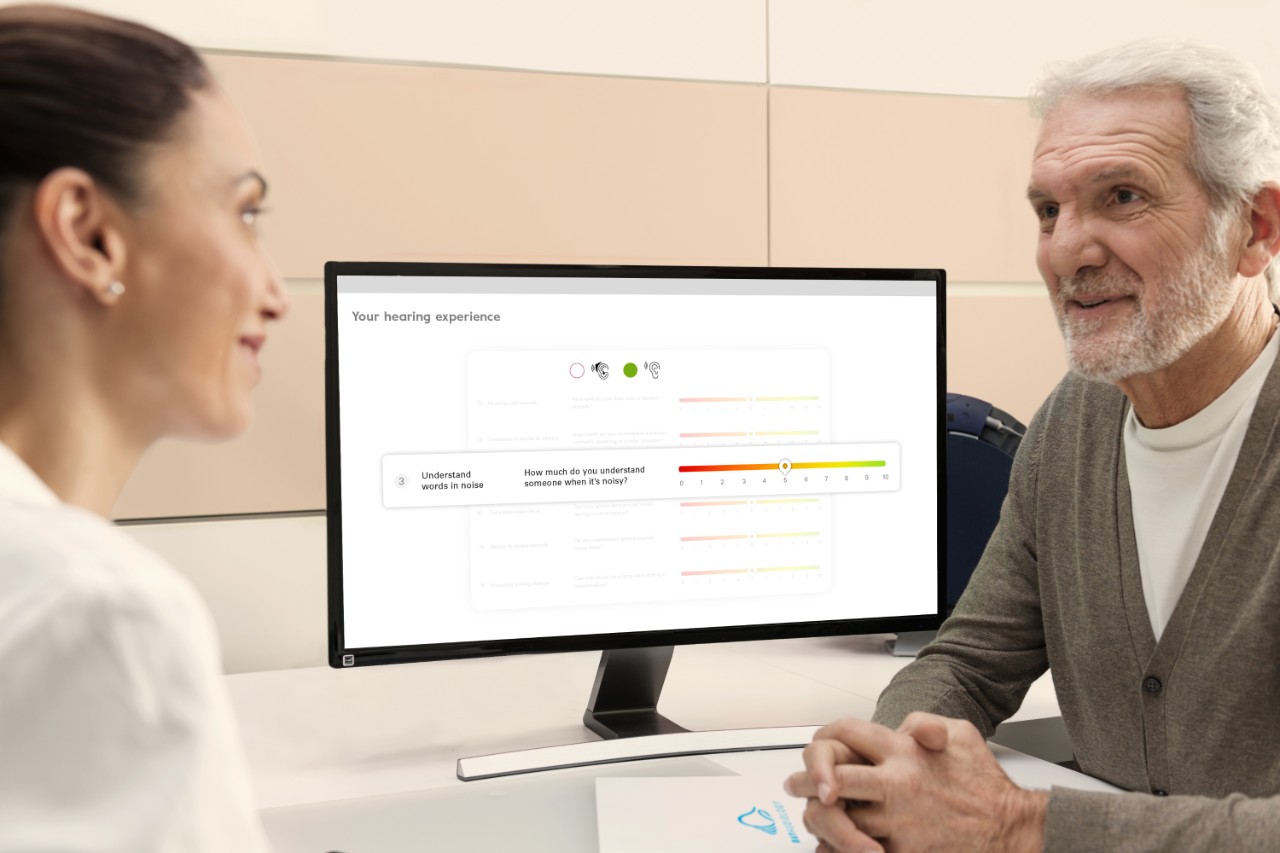 Audiologista e cliente homem num centro auditivo