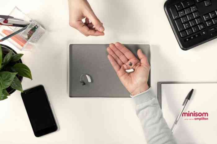 mãos a segurar aparelhos auditivos gabinete audiologista