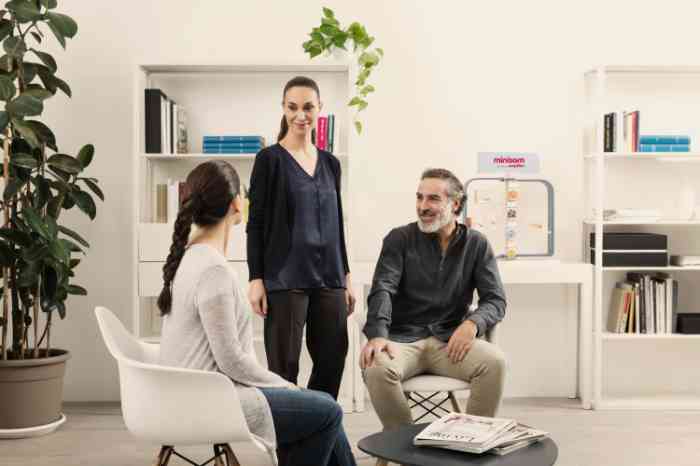 Casal a conversar com uma audiologista num centro auditivo