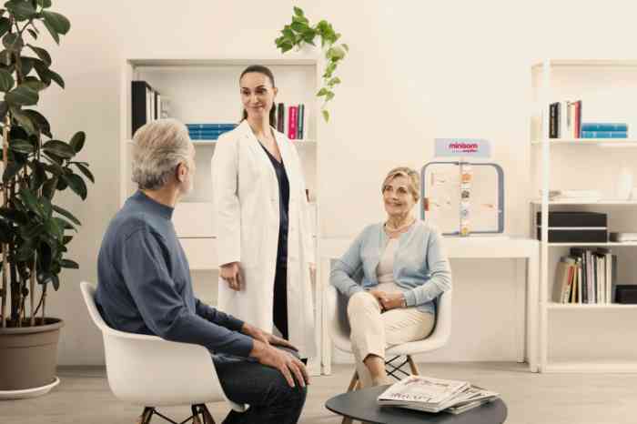 audilogista com clientes no centro auditivo