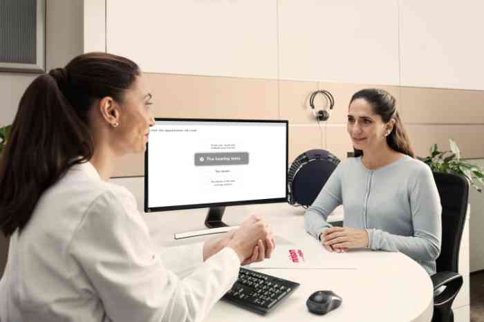 Audiologista com cliente num gabinete