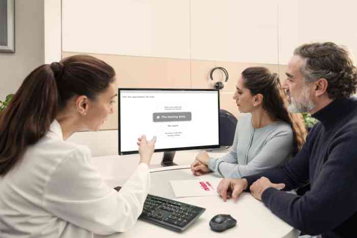 Audiologista mostra resultados do exame auditivo ao casal, e discute tipos de aparelhos auditivos.
