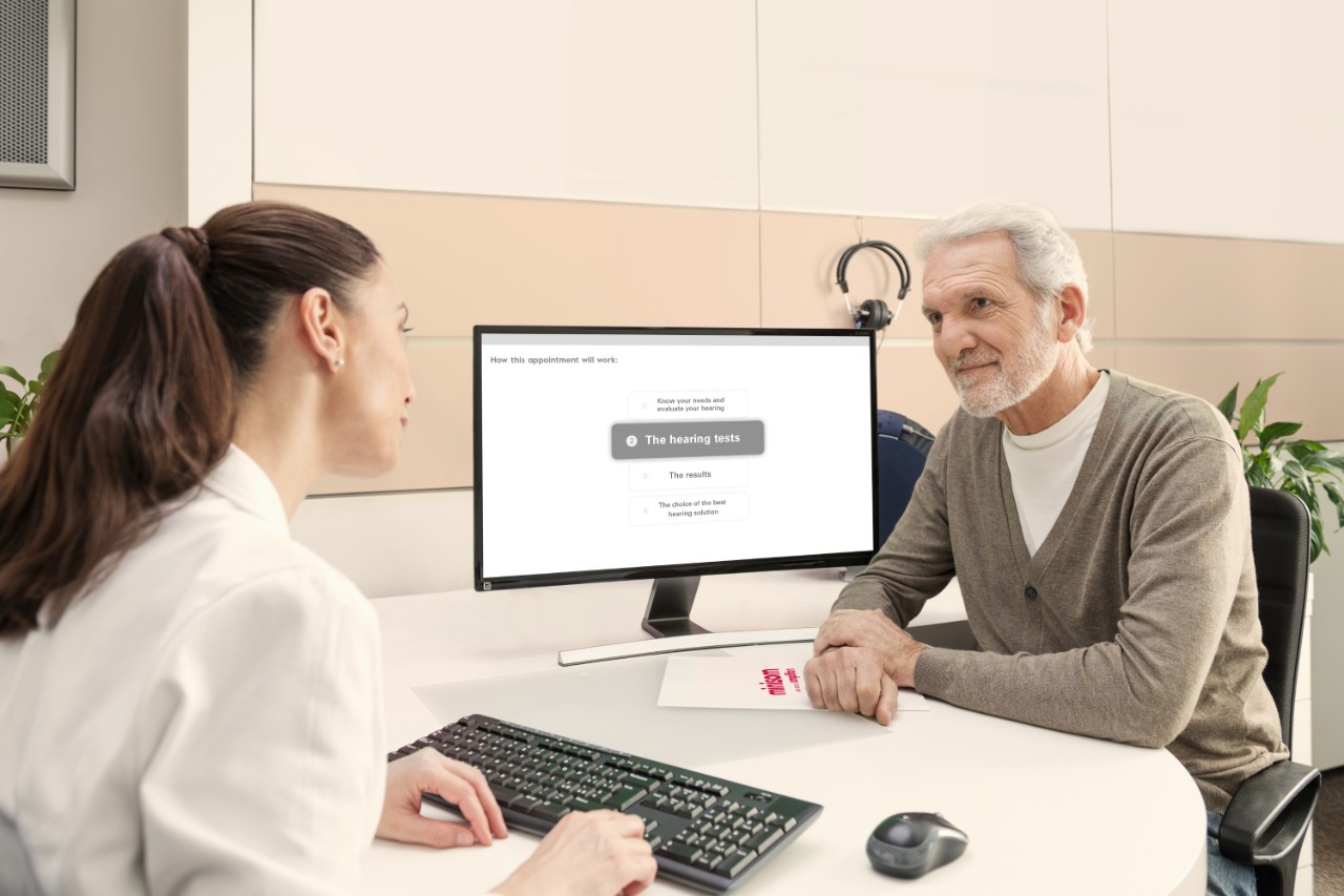 audiologista com cliente num centro auditivo