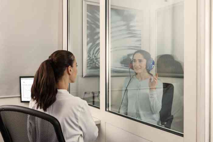 Audiologista num centro auditivo a fazer exame auditivo a senhora