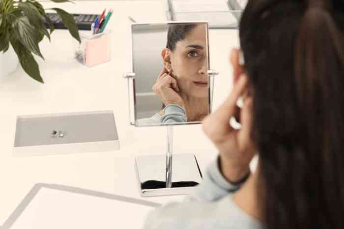Senhora vê ao espelho como o aparelhos auditivo fica na orelha