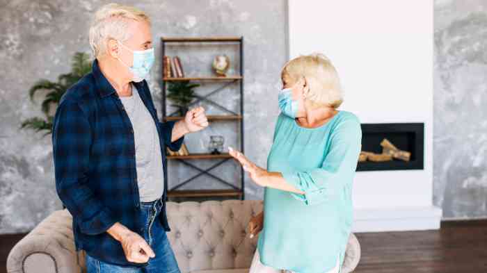 Casal idoso em casa a falar com máscara