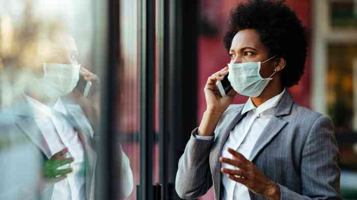 Senhora a falar ao telefone utilizando máscara