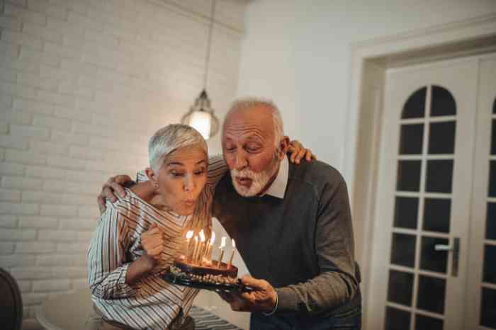 casal de idade a soprar velas de bolo aniversário