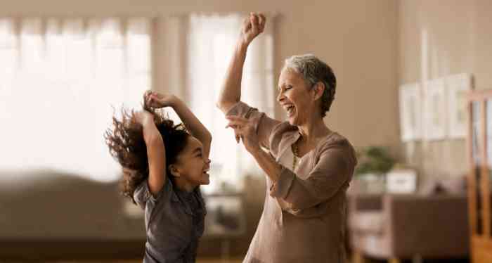 Avó e neta dançam cheias de alegria ao som da música.