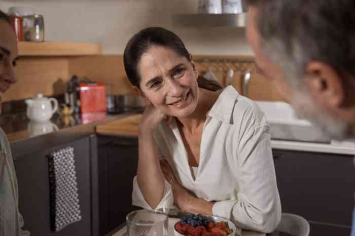 Esposa ouve as conversas alegremente ao pequeno almoço.