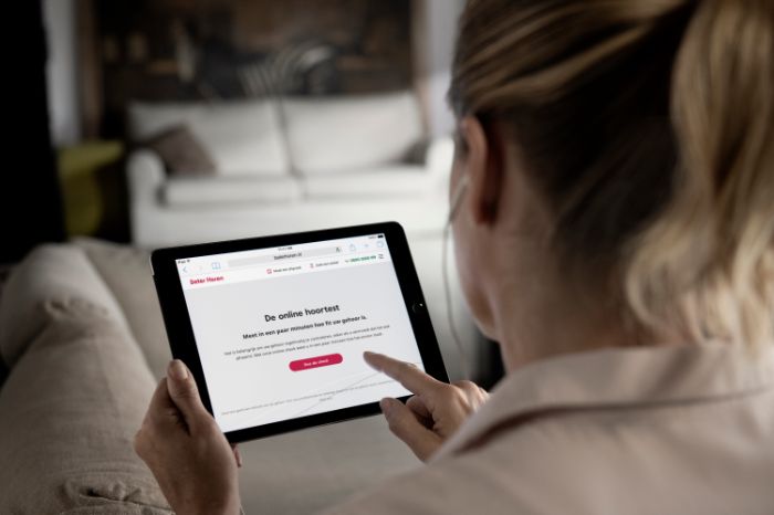 Senhora com tablet na mão marca consulta na Minisom.