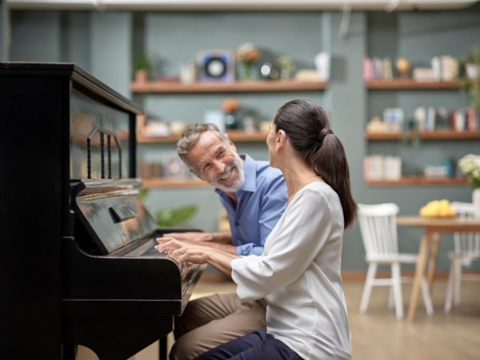 homem e mulher a tocar piano