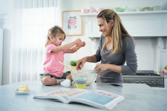 Senhora e criança em casa a cozinhar
