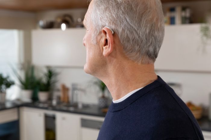 Homem com aparelho retroauricular visto de perfil