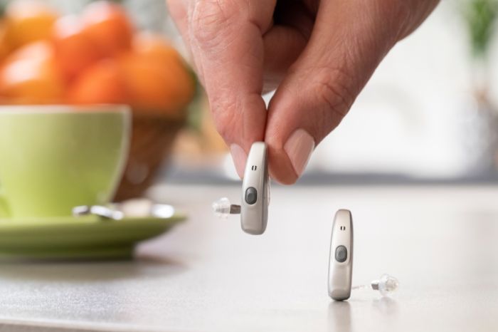 Senhor a colocar os seus aparelhos auditivos na mesa