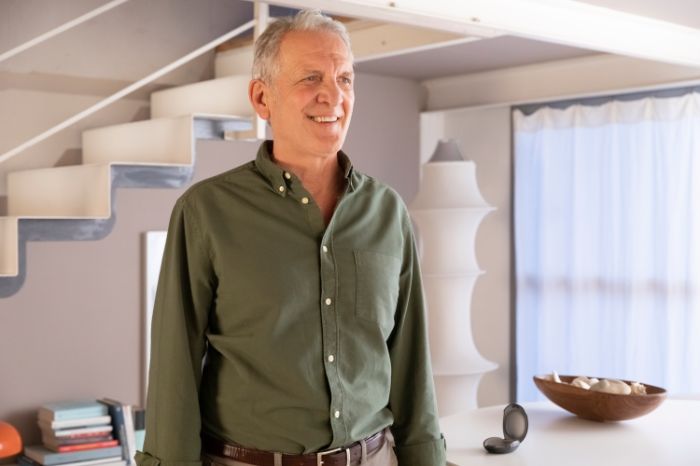 senhor com aparelhos auditivos ampli-mini nos ouvidos