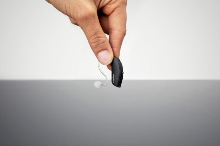 Homem a segurar o aparelho auditivo Ampli-mini