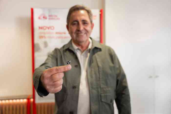 Cliente Minisom, Joaquim Cruz, com o aparelho auditivo ampli-mini na mão