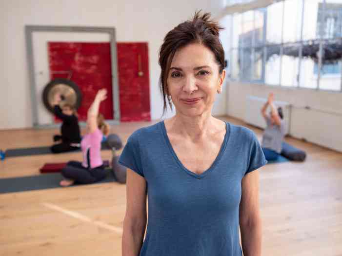 Várias senhoras num ginásio a fazerem exercício.